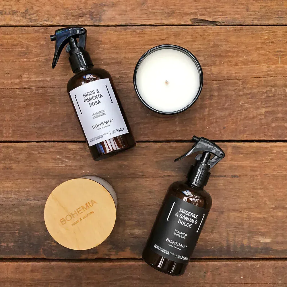 Botella de spray marrón y bolsa de cuentas beige sobre una superficie texturizada blanca, posiblemente una cama.