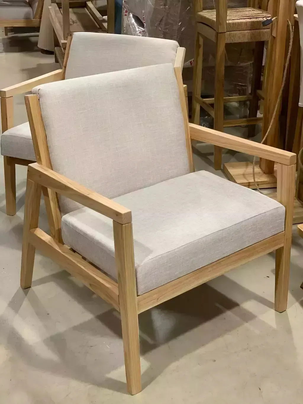 Sillón de madera con cojines color gris claro en taller.