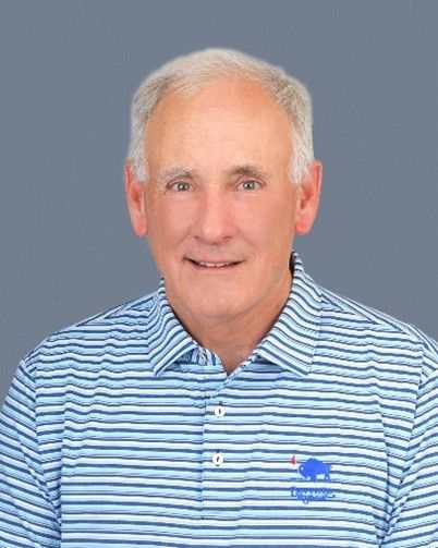 A man wearing a blue and white striped polo shirt is smiling for the camera.