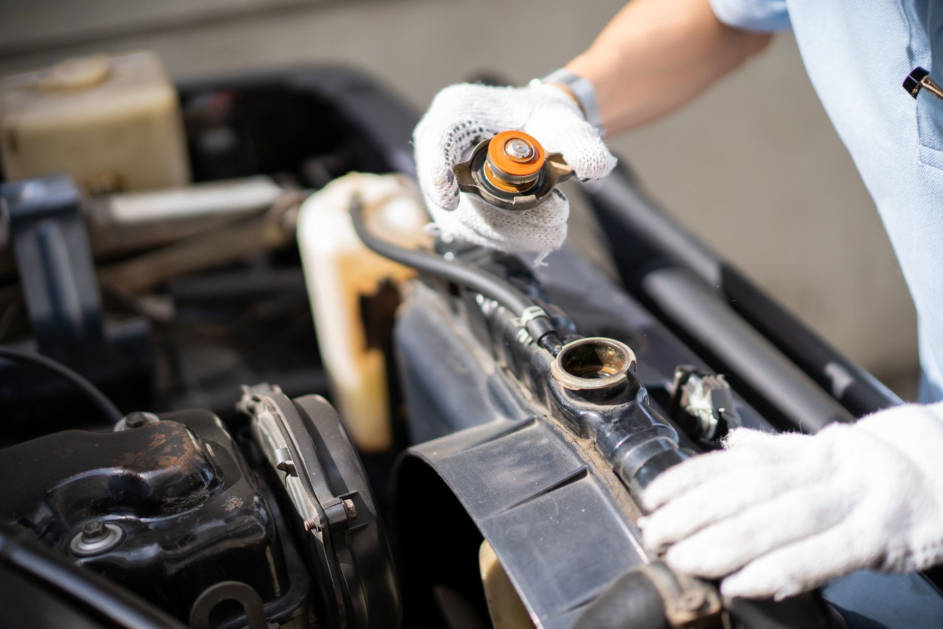 A person is opening a radiator cap on a car | Calgary Auto And Alignment