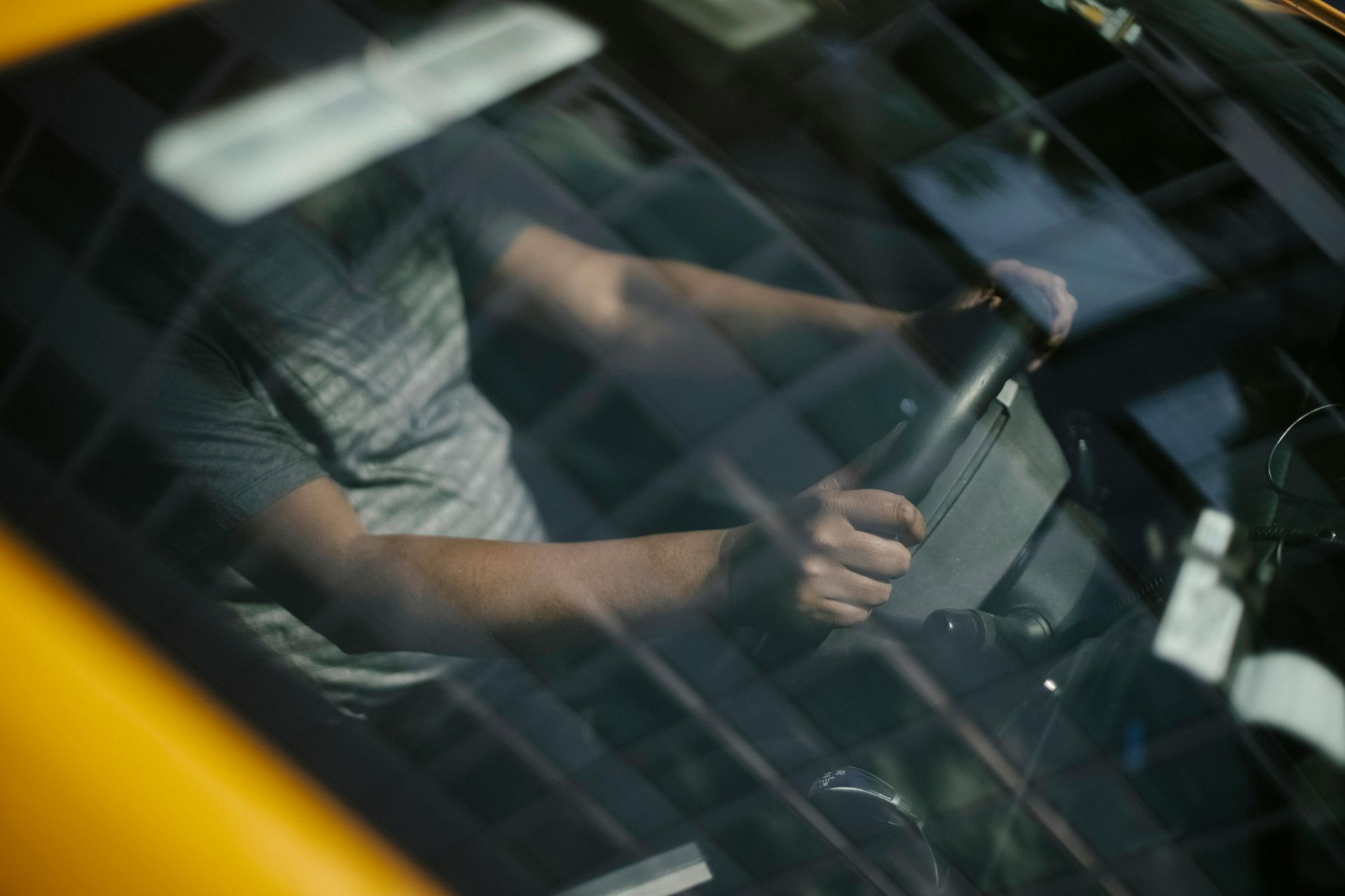 A man is driving a car with his hands on the steering wheel. | Calgary Auto And Alignment