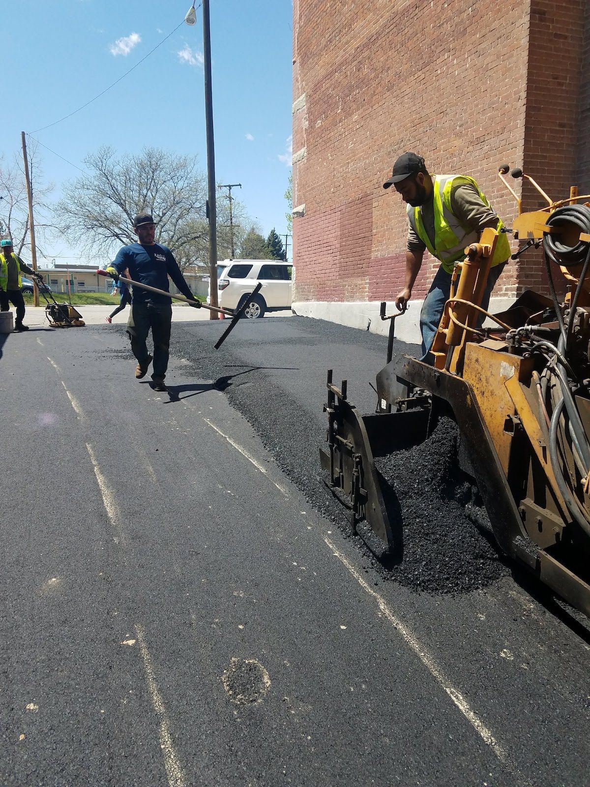 A group of construction workers are working on a road.