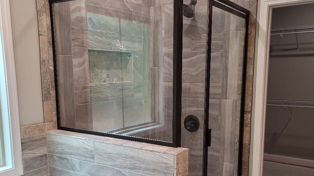 A bathroom with a walk in shower and a window.