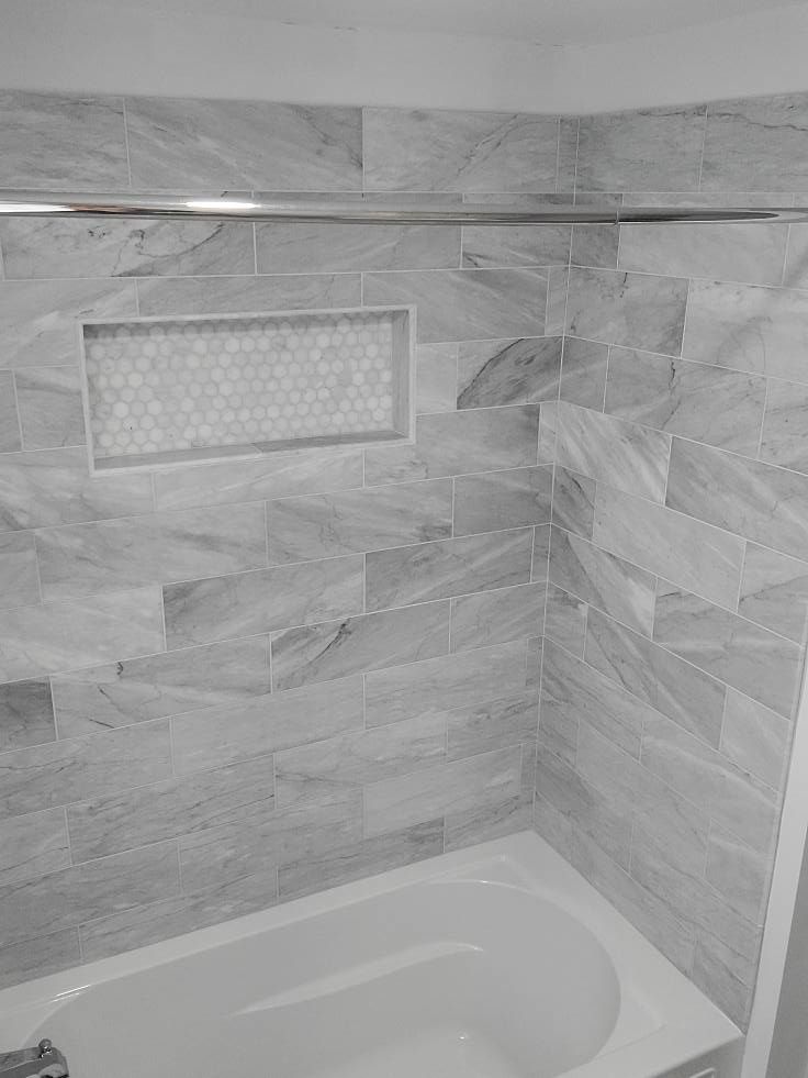 A black and white photo of a bathtub in a bathroom.