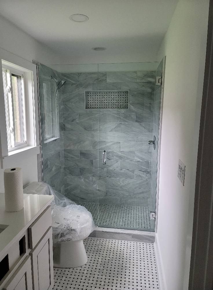 A bathroom with a walk in shower and a toilet.