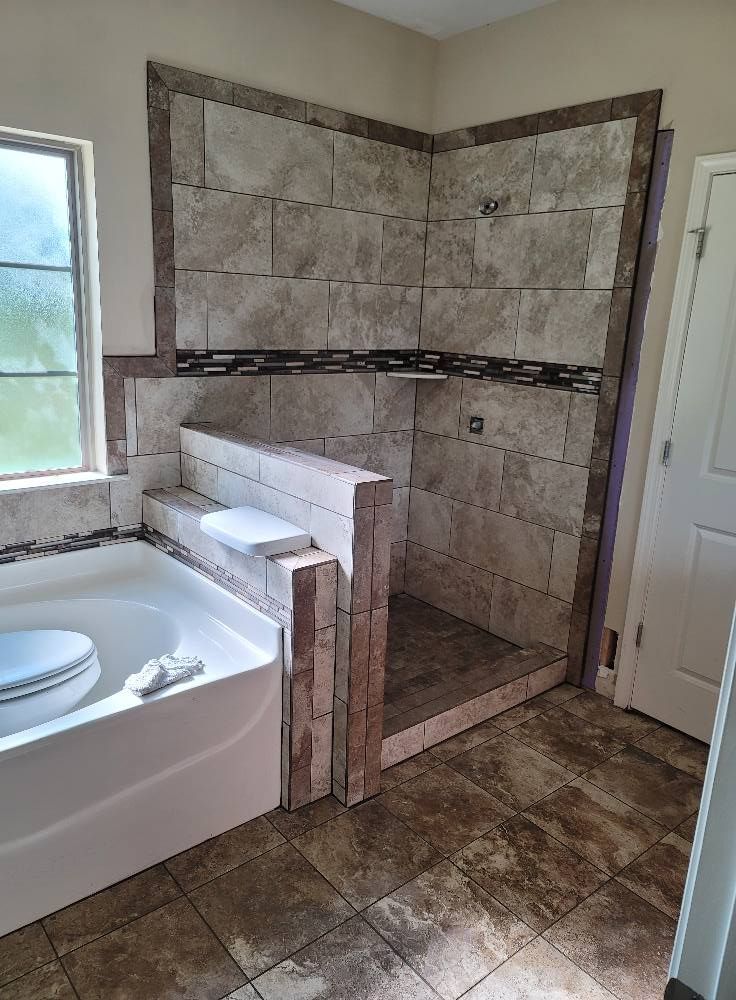 A bathroom with a tub and a walk in shower.