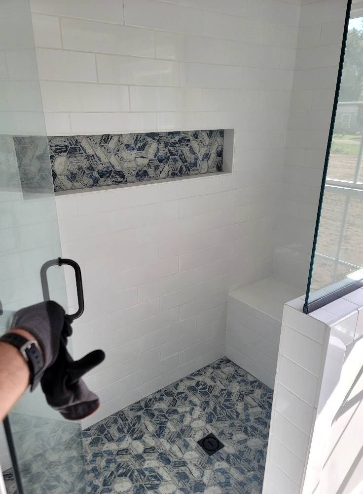 A person is taking a picture of a shower in a bathroom.