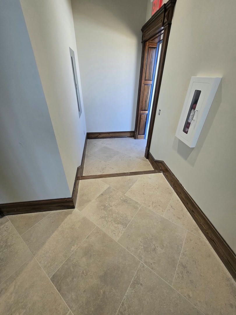 A hallway with tile floors and a picture on the wall.