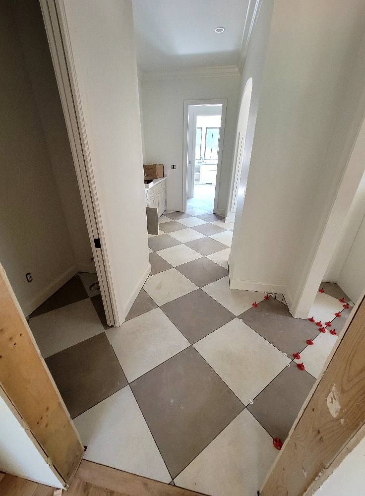 A hallway with a checkered tile floor in a house under construction.
