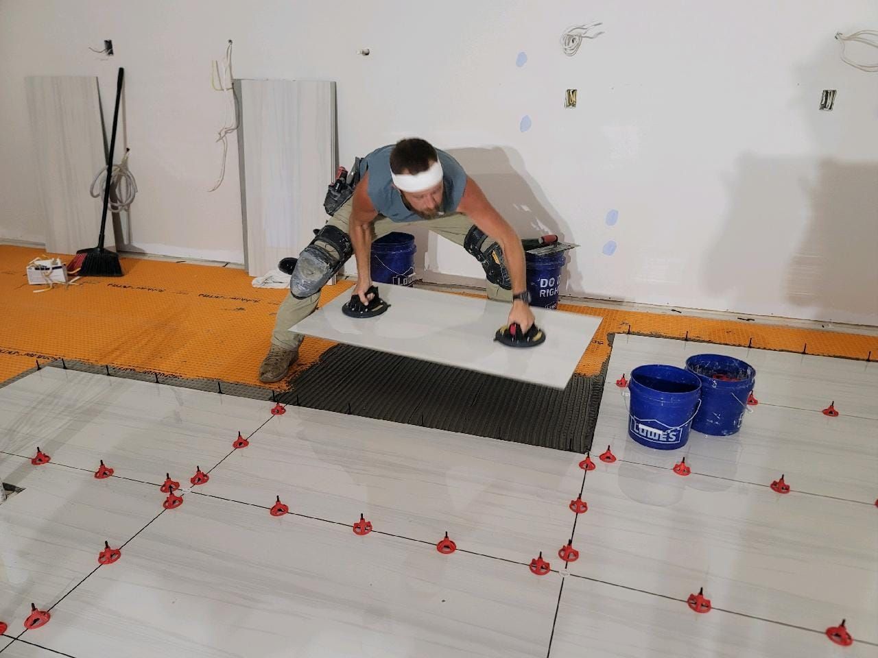 A man is laying a tile on a floor