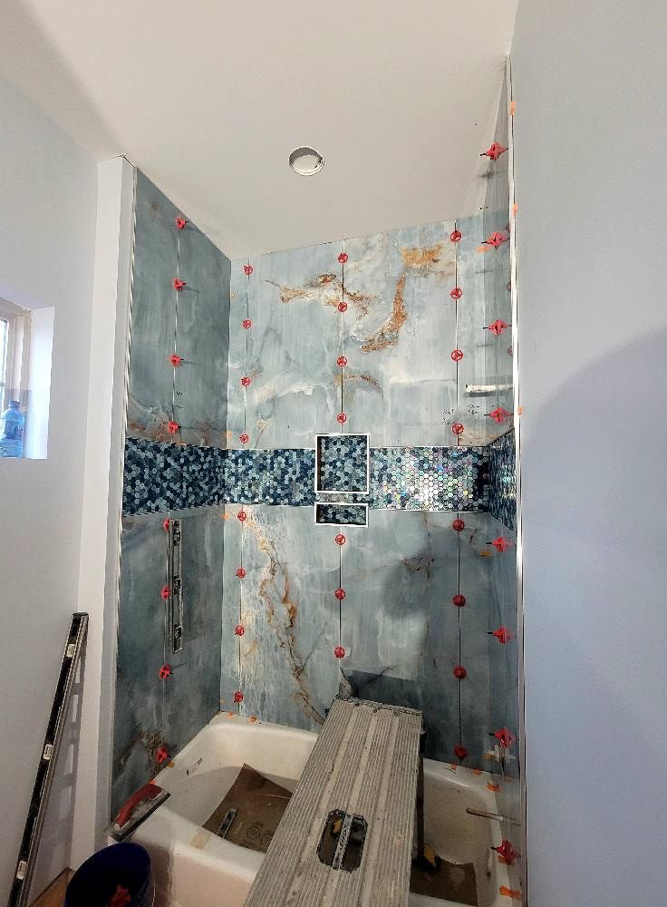 A bathroom with a tub and a shower being remodeled.