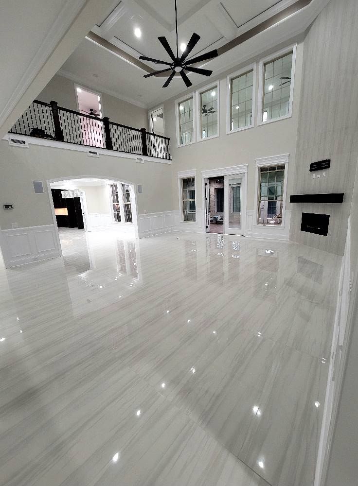 A large empty room with a ceiling fan and a fireplace.