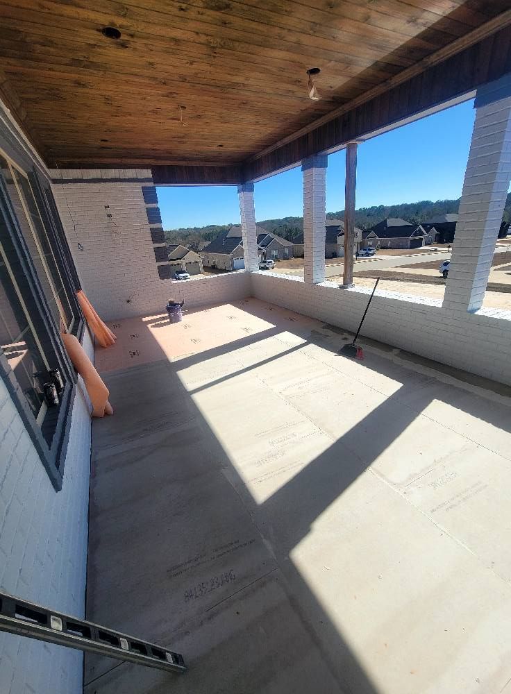 A large porch with a wooden ceiling and a broom.