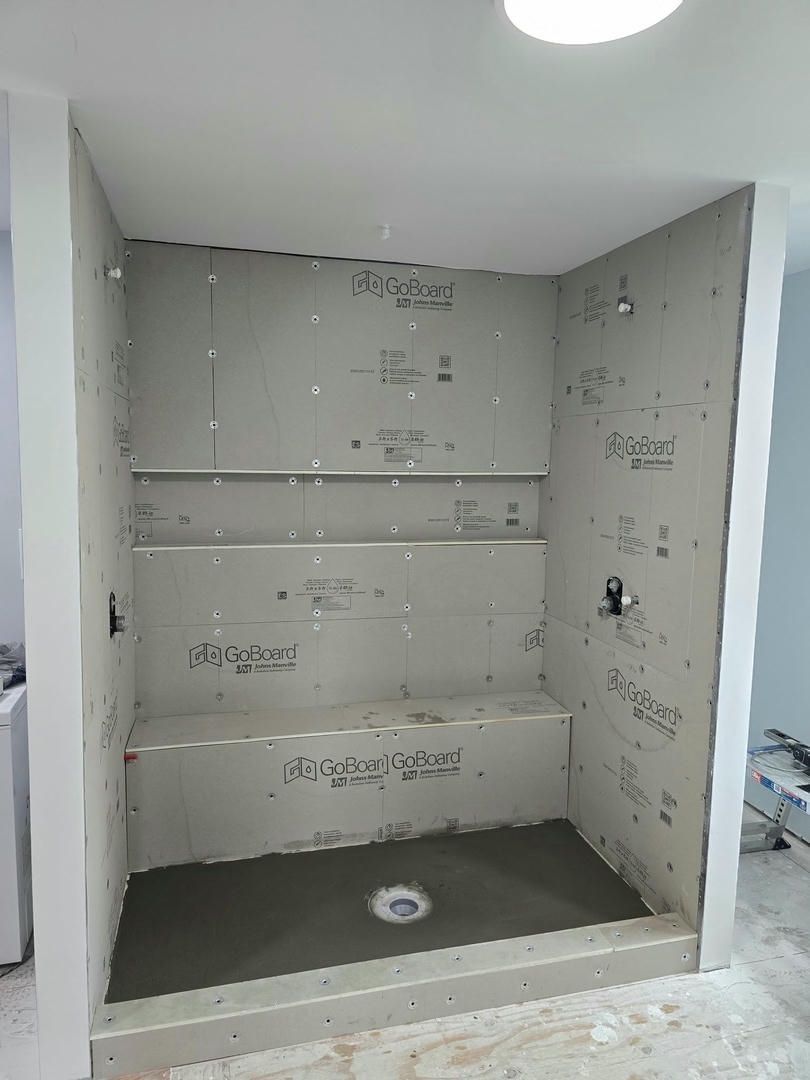 A shower stall is being built in a bathroom.