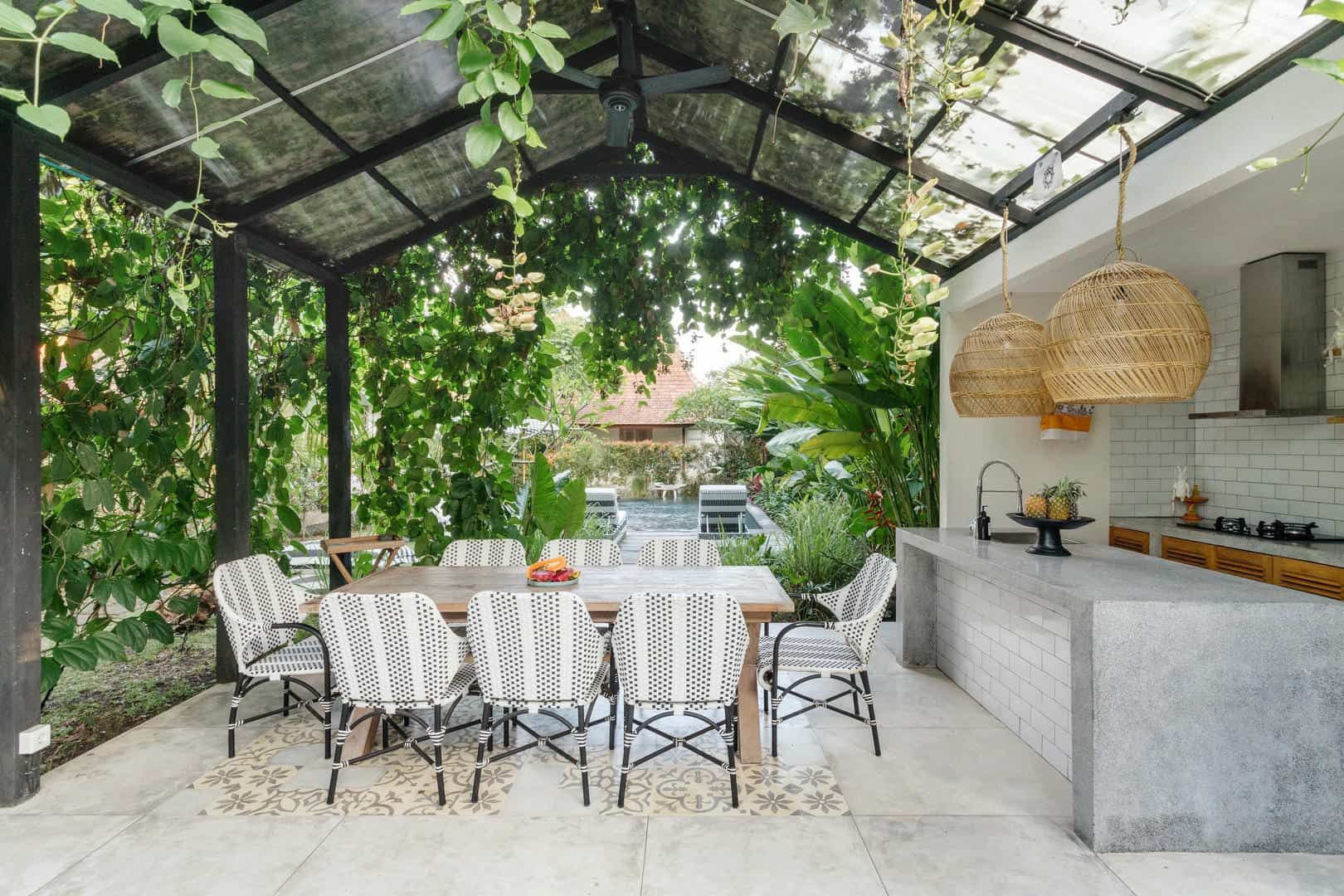 A dining room with a table and chairs under a glass roof.