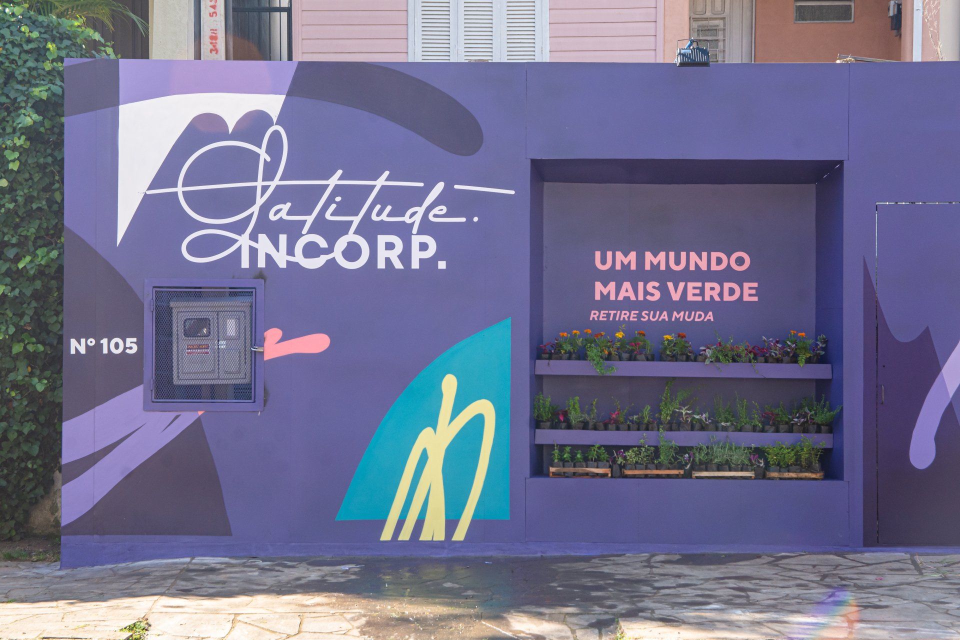 Uma parede roxa com uma placa que diz um mundo mais verde