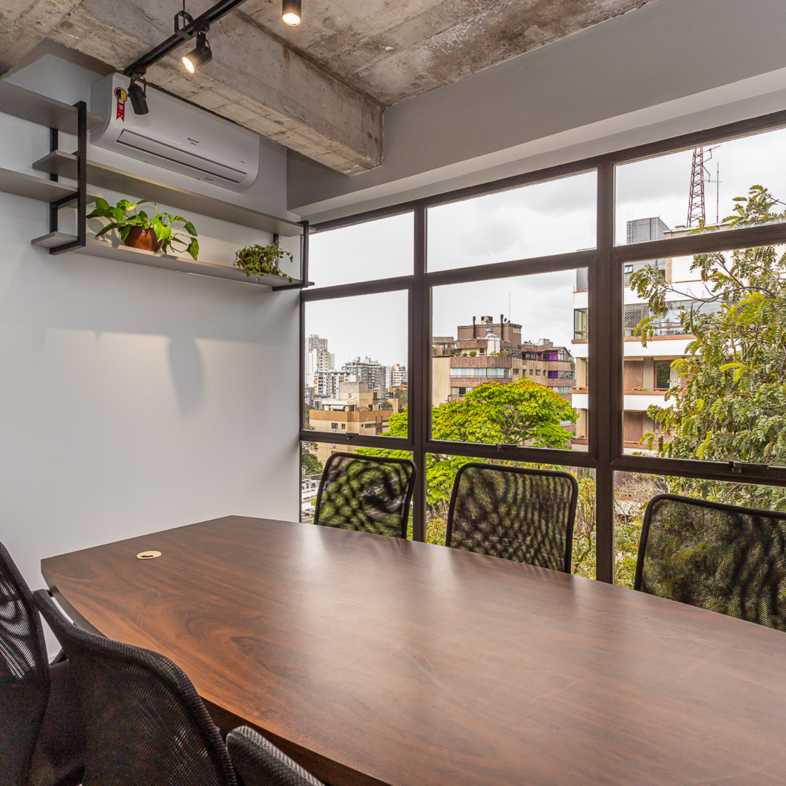 Uma sala de conferências com uma longa mesa e cadeiras de madeira