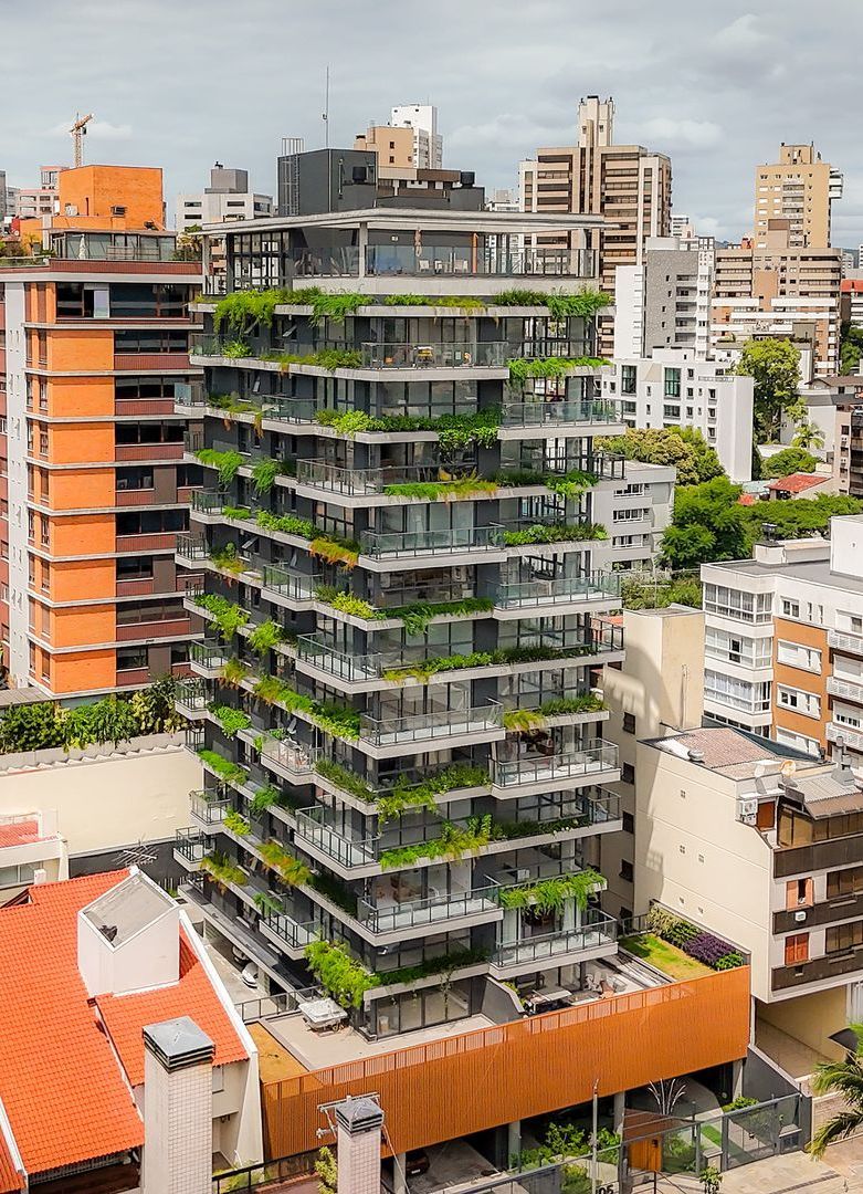 Um prédio alto com muitas varandas e plantas