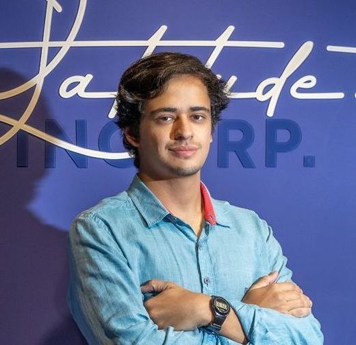 Um homem de camisa azul com os braços cruzados