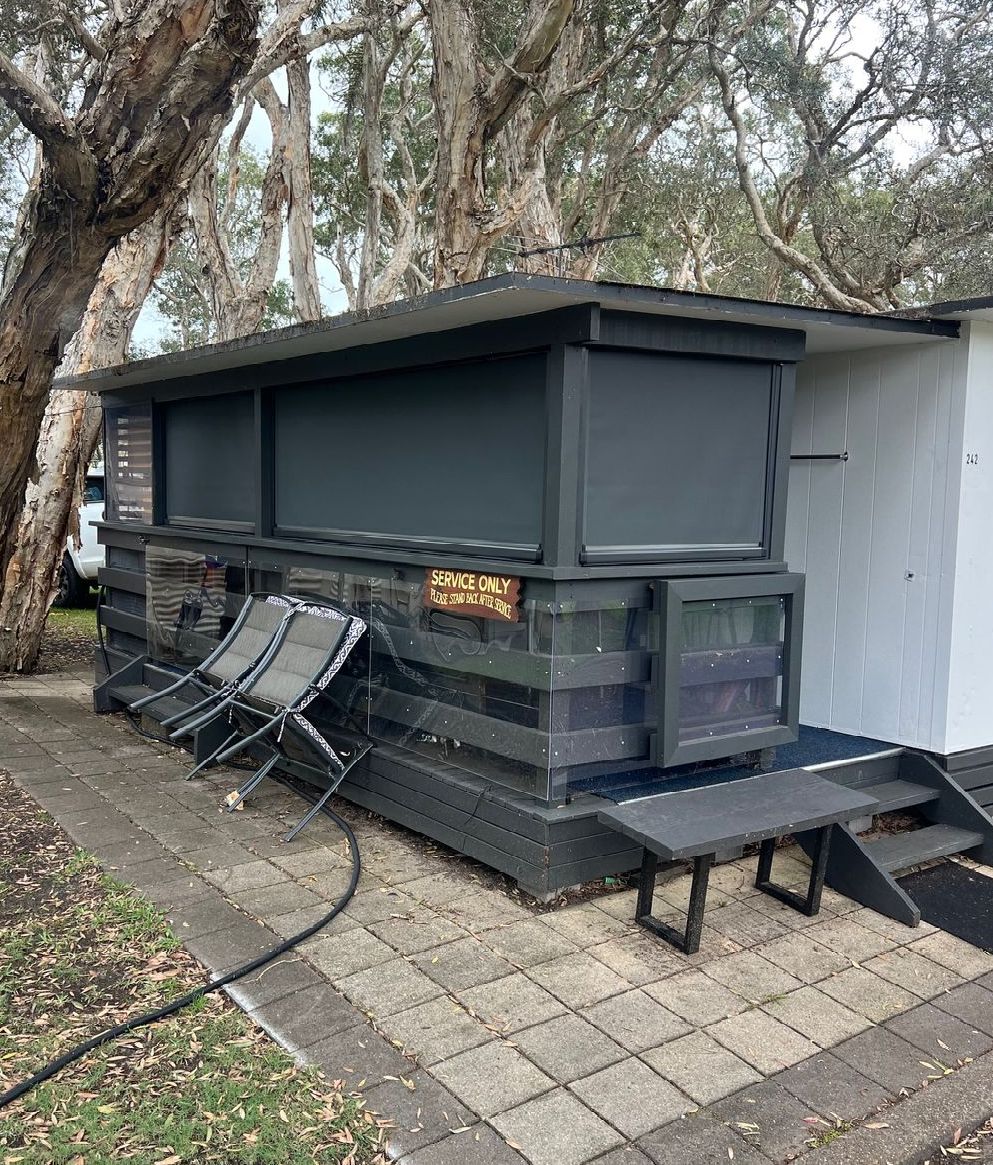 A Patio With A Couch And A Table Under A Canopy — Outdoor Blinds In Berkeley Vale, NSW