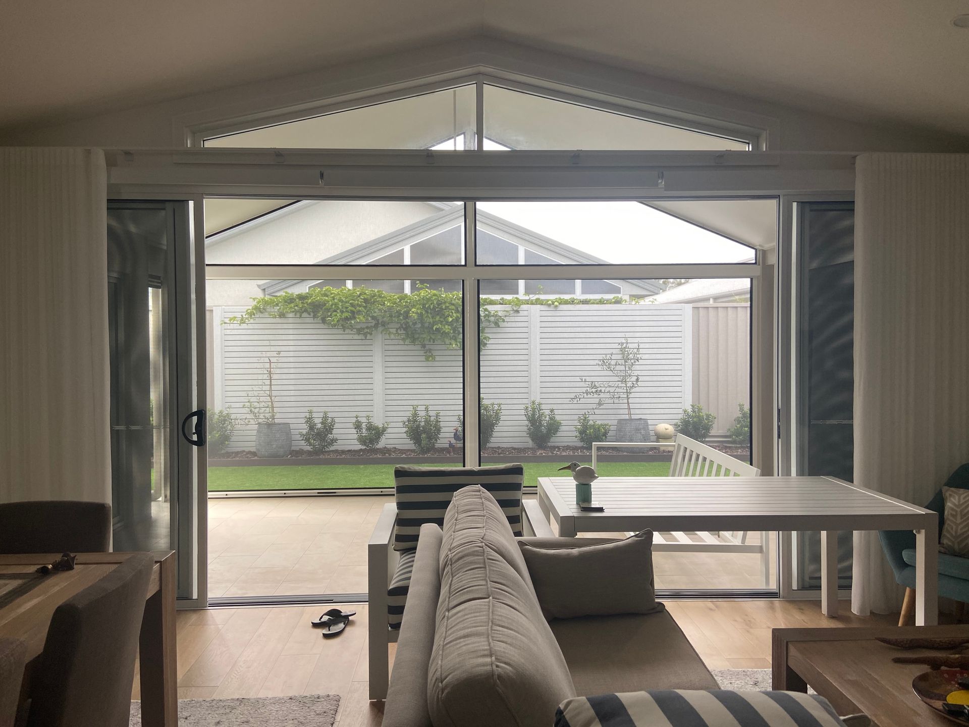 A Dining Room With A Table And Chairs And Shutters On The Windows — Outdoor Blinds In Berkeley Vale, NSW