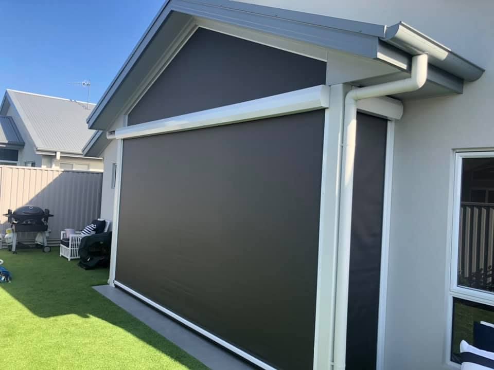A House With A Large Screen On The Side Of It — Outdoor Blinds In Lake Macquarie, NSW