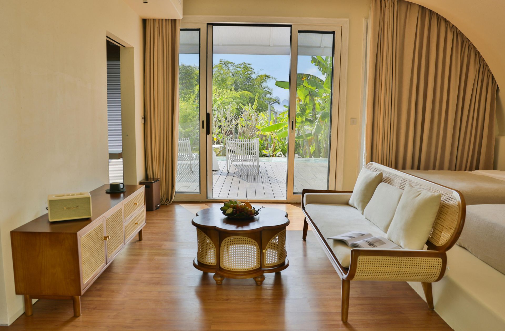 Living room with wooden furniture, sliding glass doors to a patio, and beige curtains.