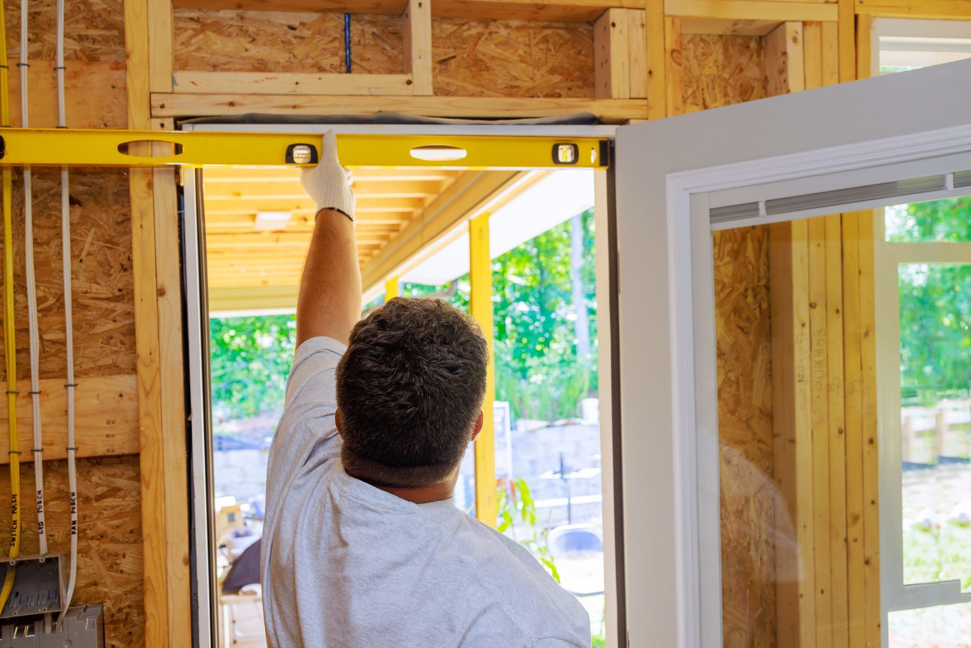 Person using a level on a door frame in a construction setting.