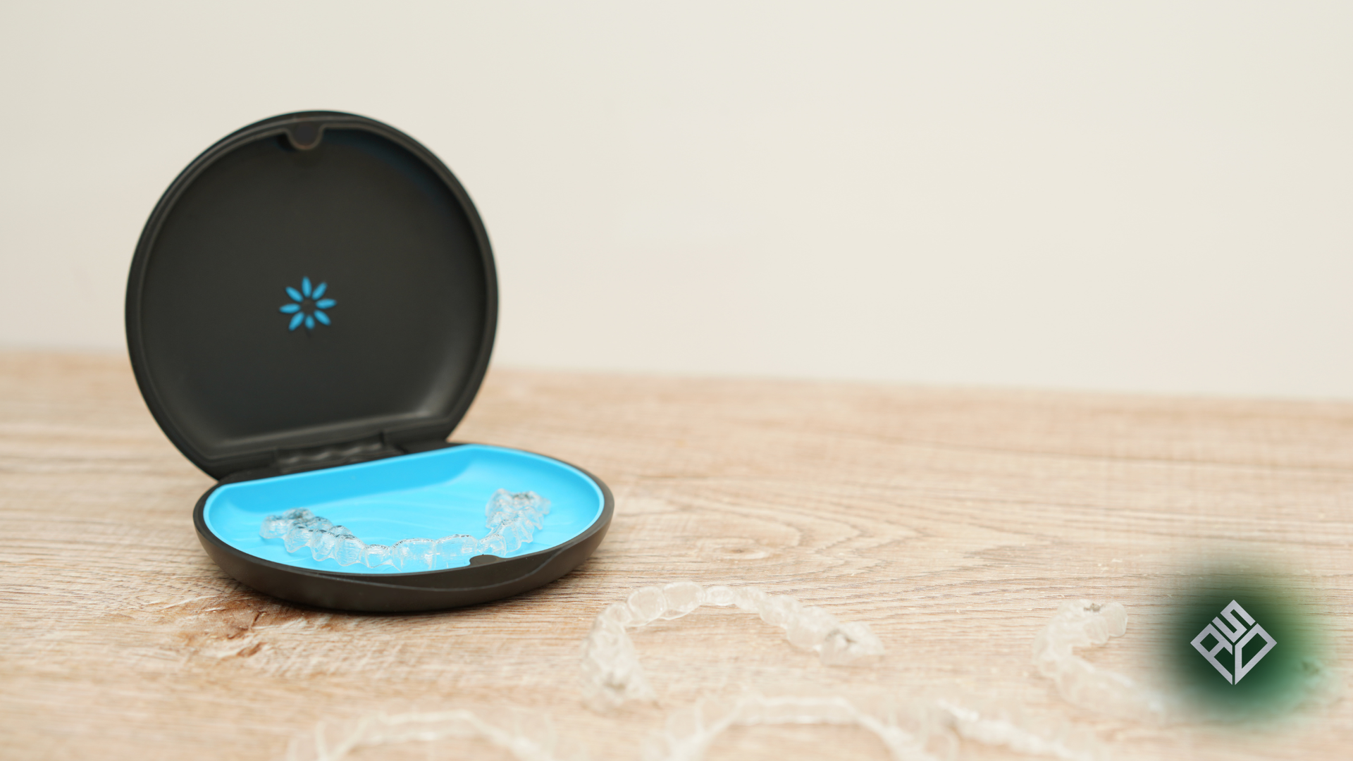 Person holding clear aligner, smiling, preparing to put it in mouth.