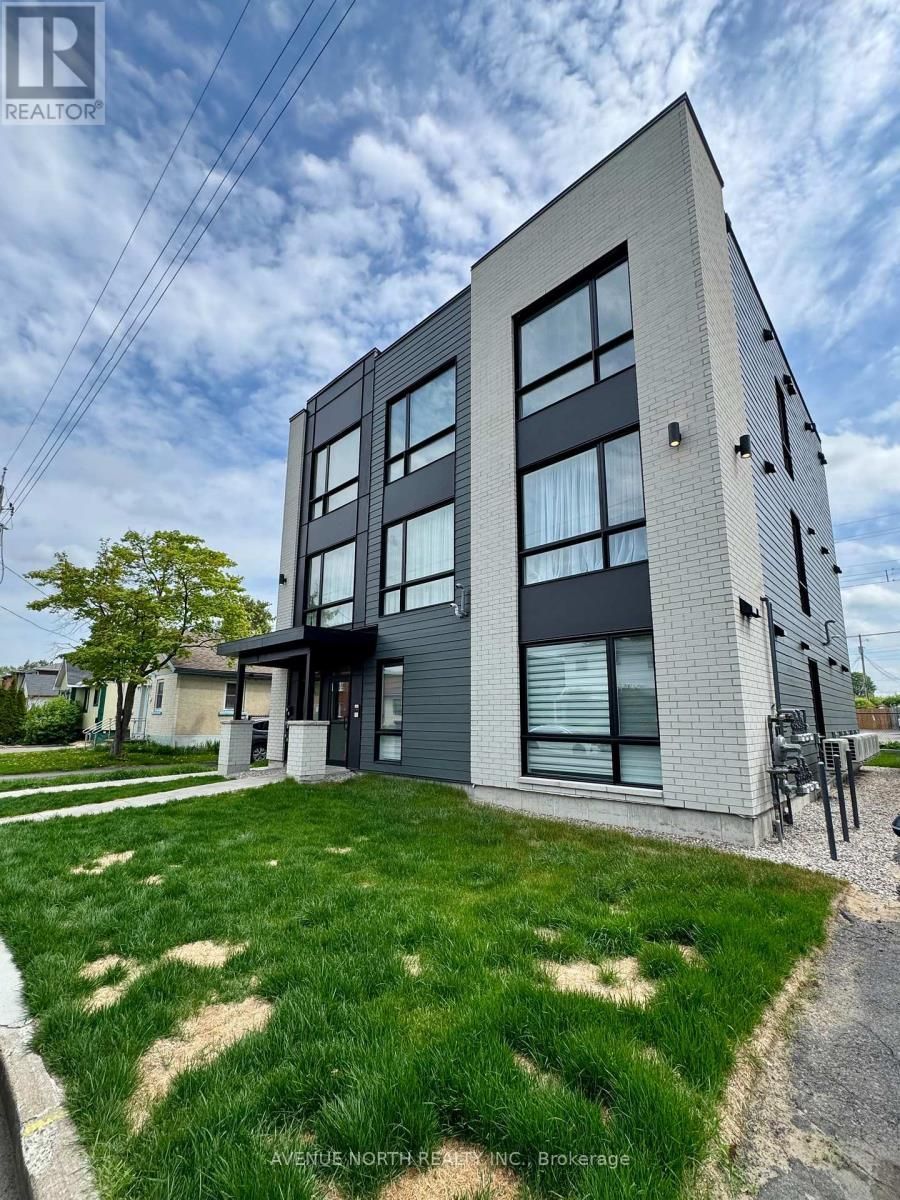 Un grand immeuble d'appartements avec beaucoup de fenêtres et beaucoup d'herbe devant.