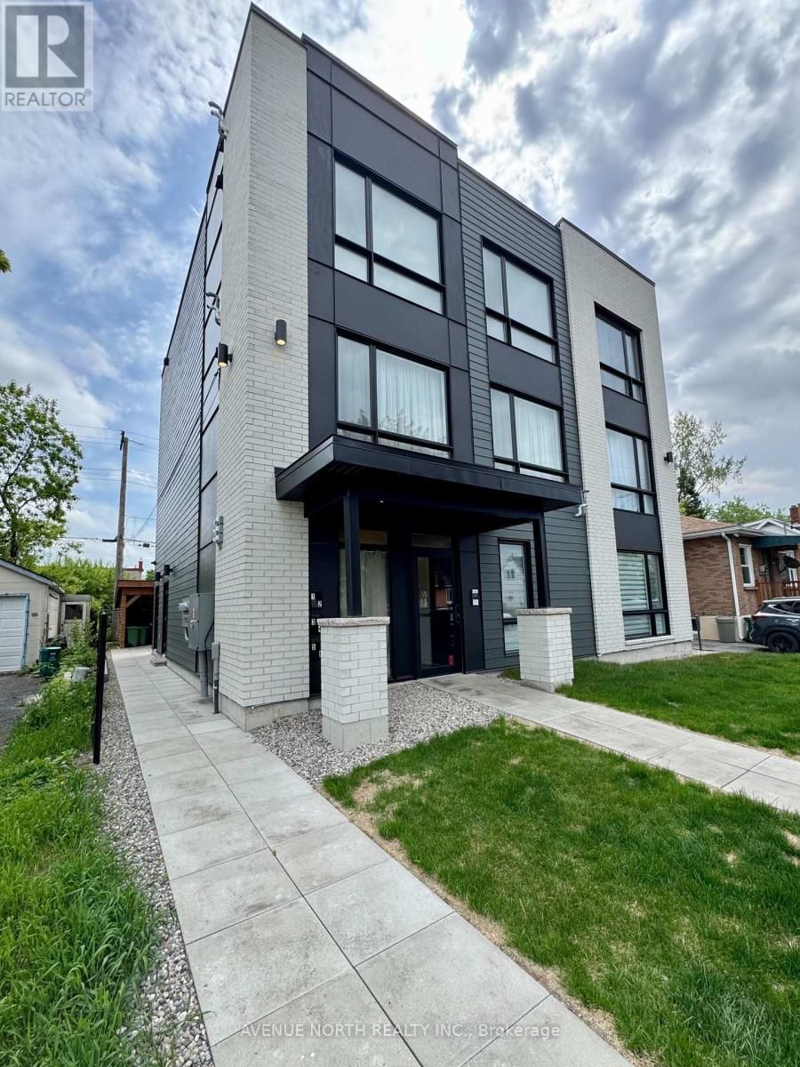 Un grand bâtiment avec beaucoup de fenêtres et un trottoir devant.