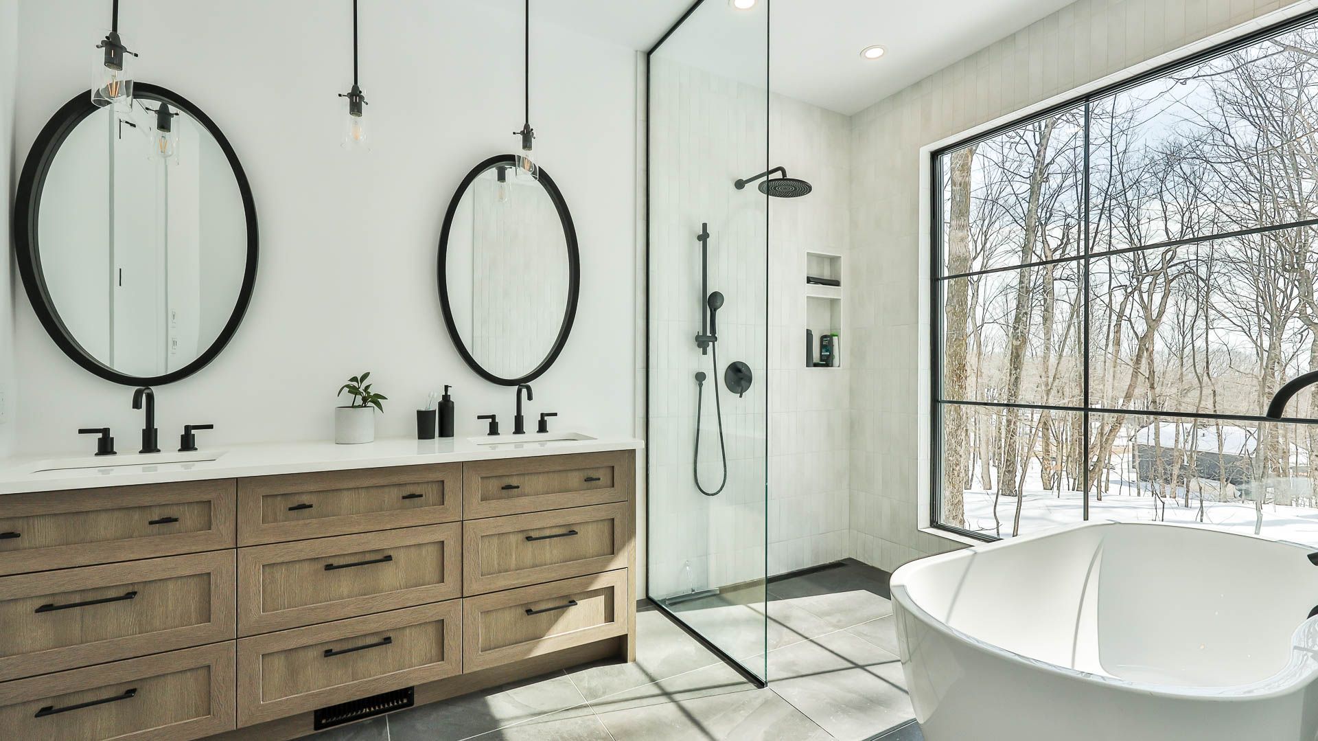 Une salle de bain avec deux lavabos, une baignoire, une douche et une grande fenêtre.