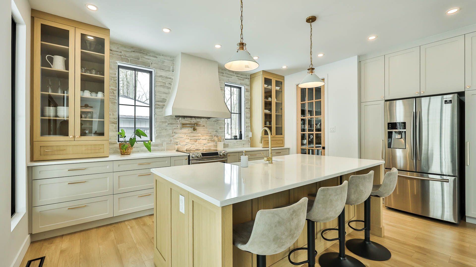 Une cuisine avec des armoires blanches, des appareils électroménagers en acier inoxydable et un grand îlot.