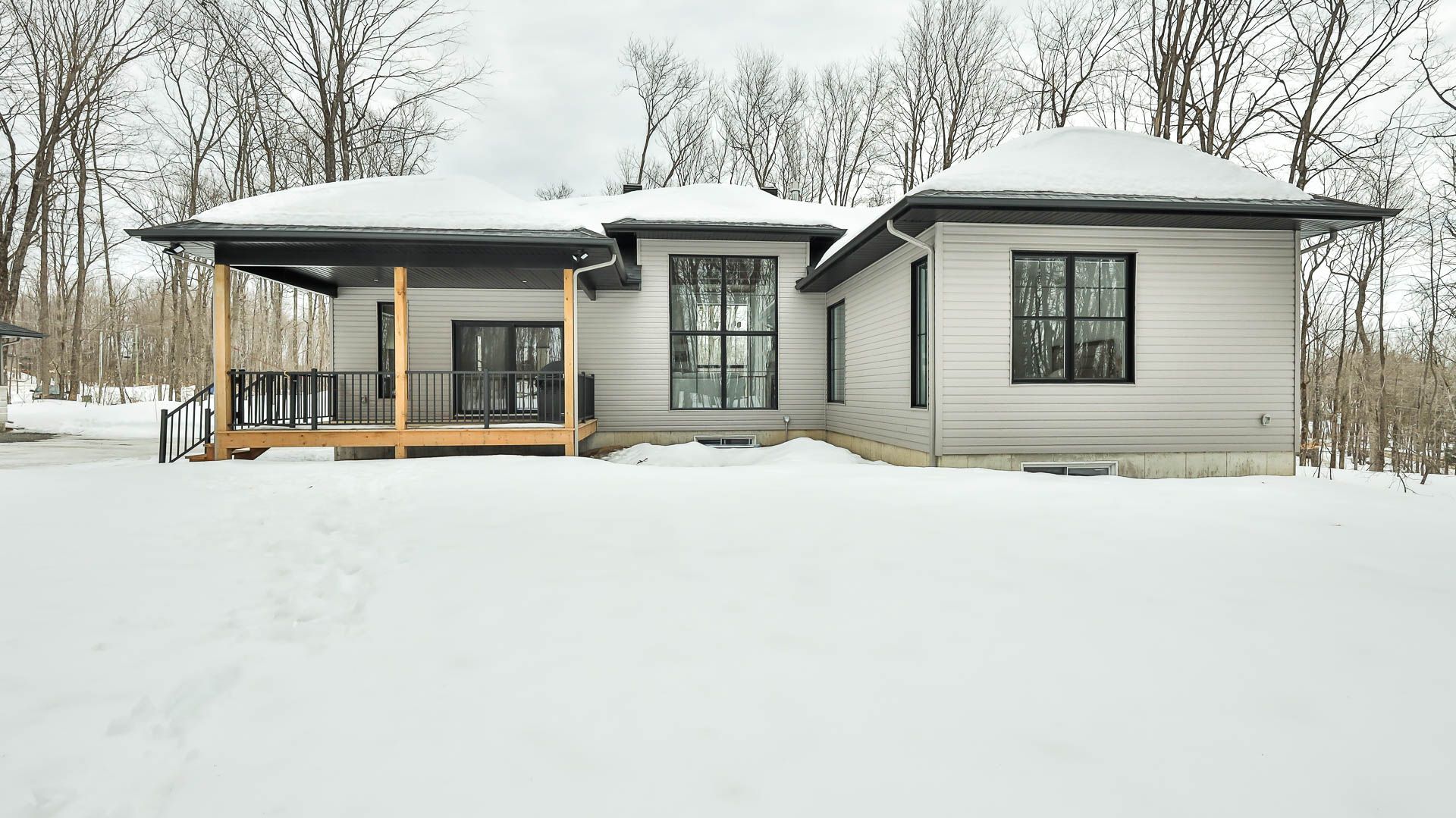 Une maison est située au milieu d'un champ couvert de neige.