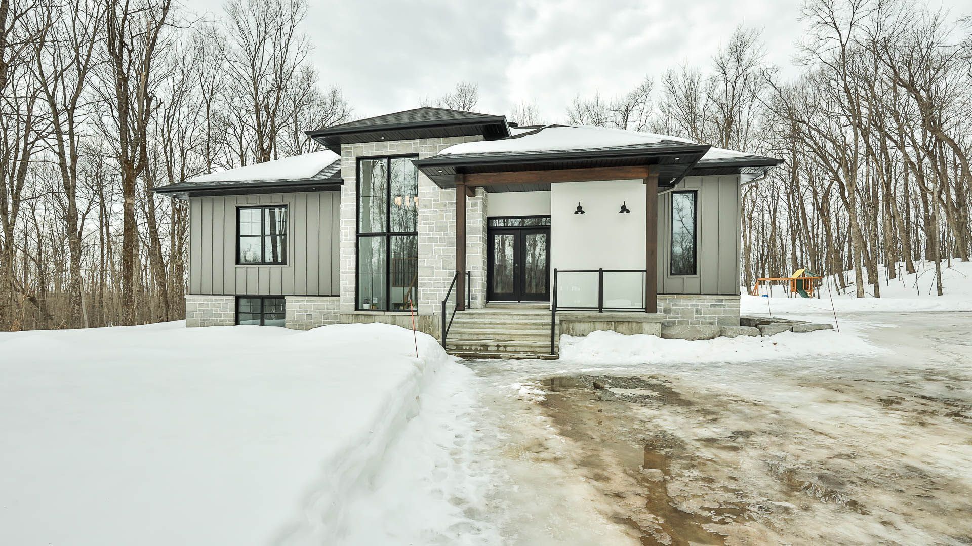 Une maison est située au milieu d'une forêt enneigée.
