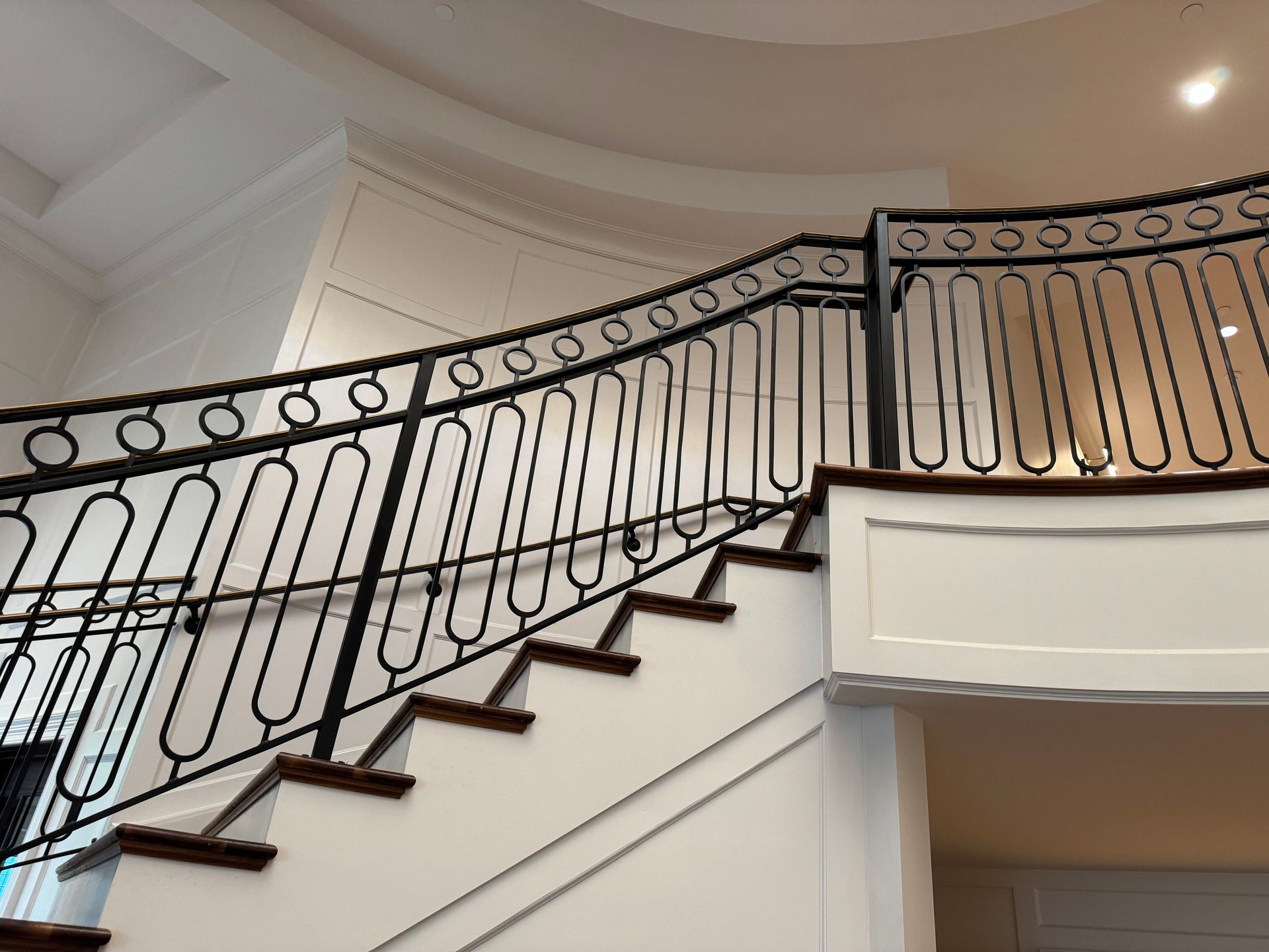 A staircase with a wrought iron railing and wooden steps