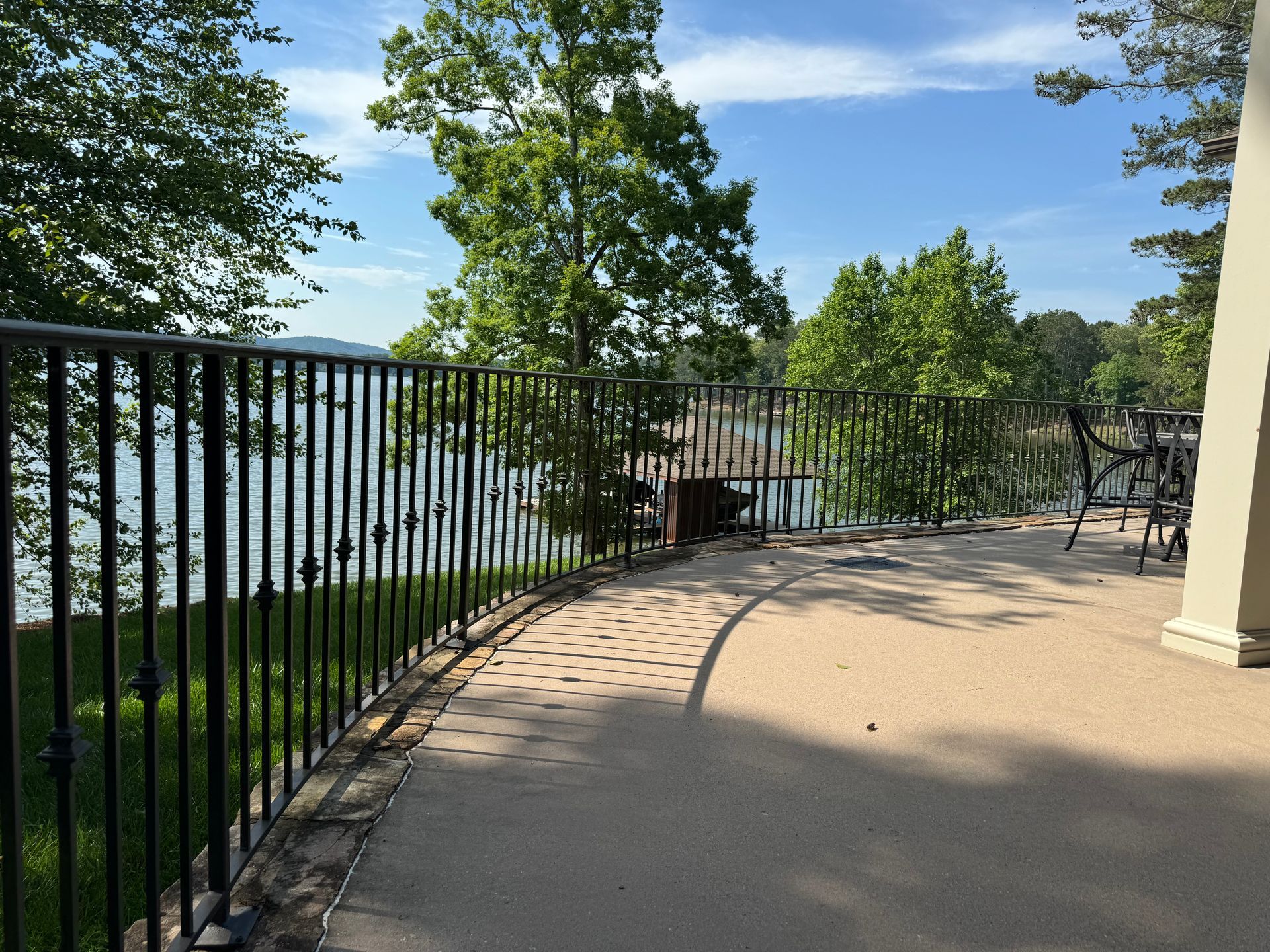 A balcony overlooking a lake with a wrought iron railing
