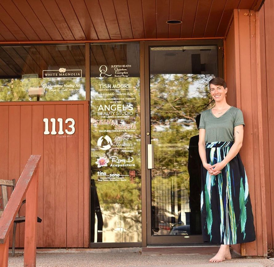 A woman is standing in front of a door with the number 1113 on it