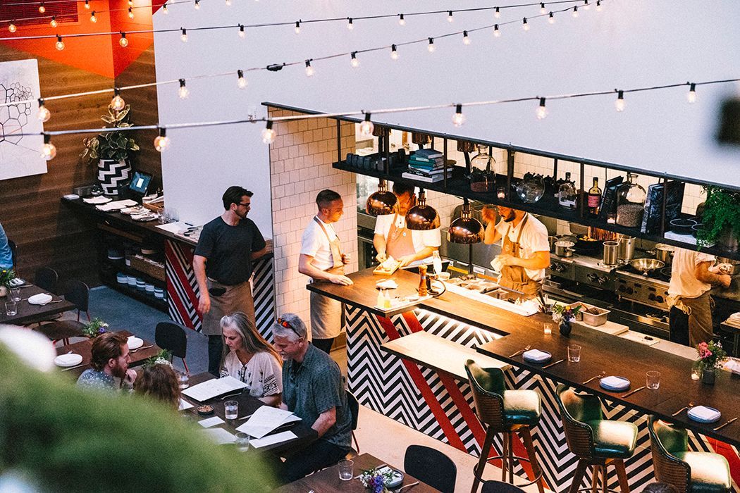 A group of people are sitting at tables in a restaurant.