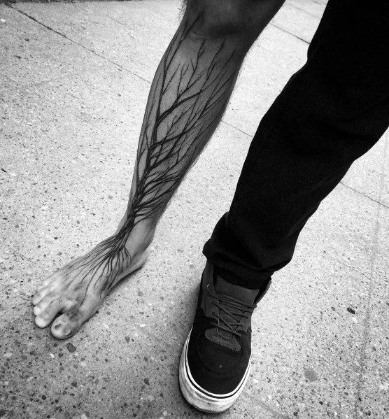 A person with a tree tattoo on their leg