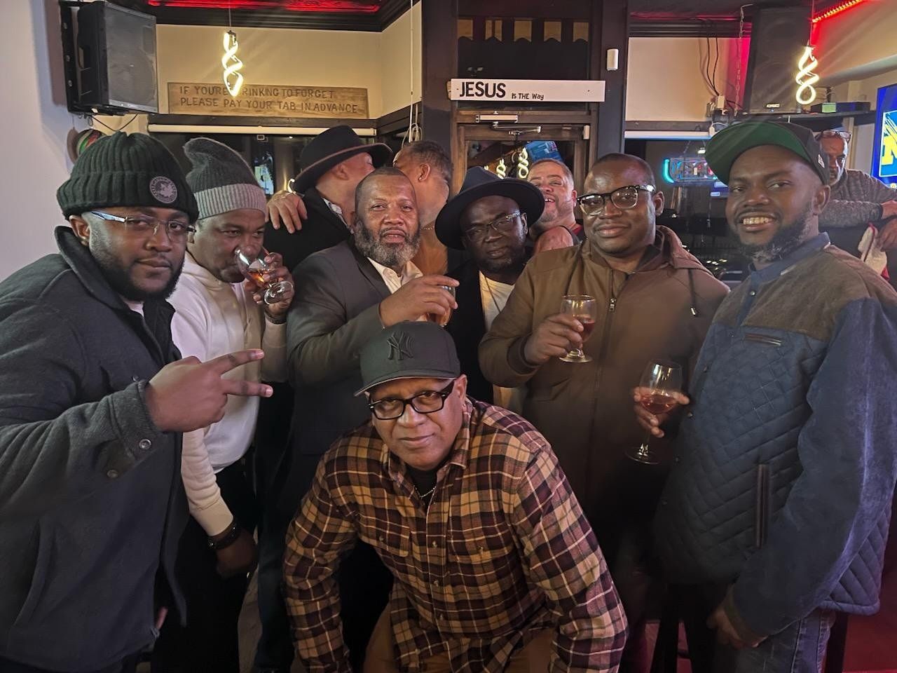 A group of men are posing for a picture in a bar
