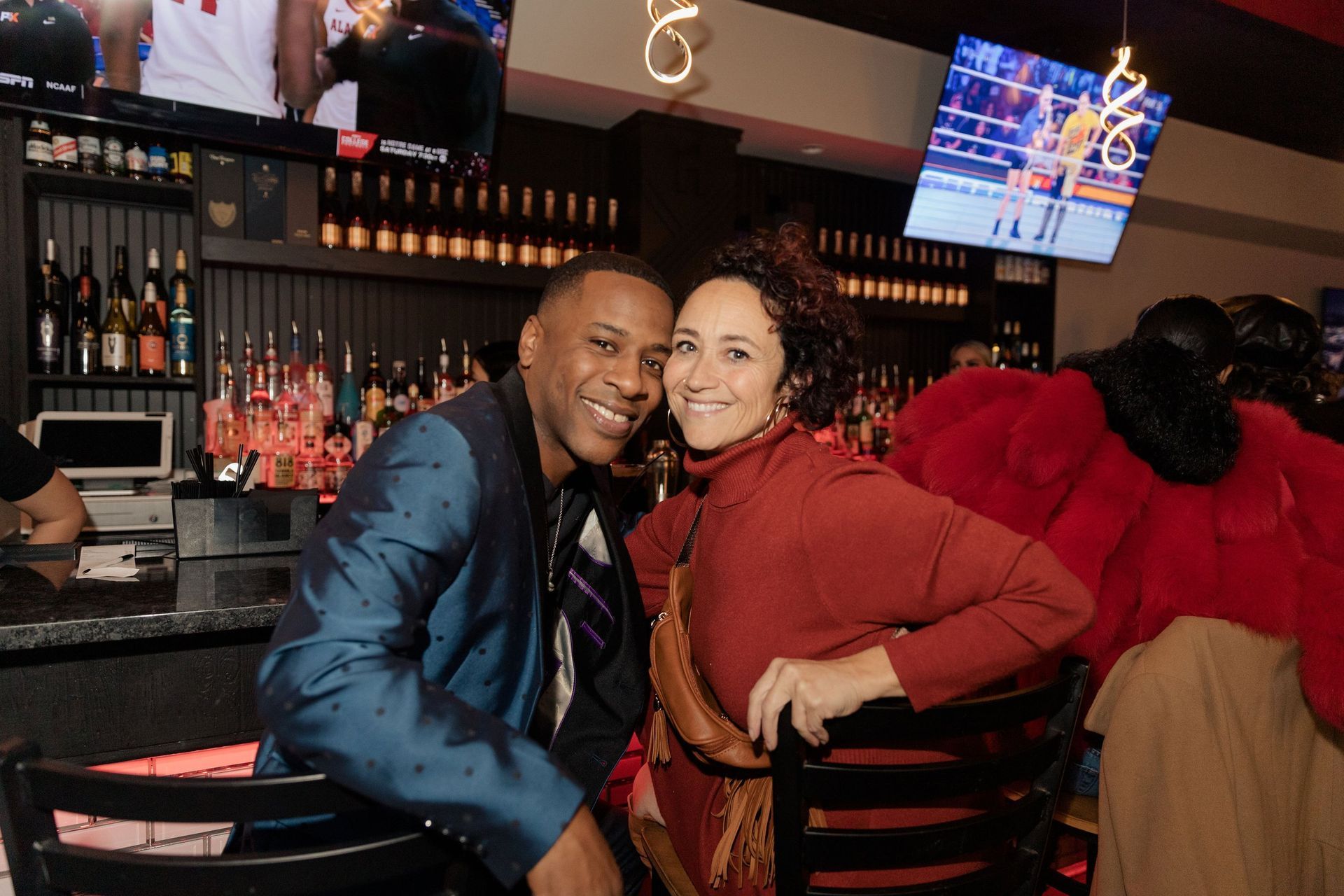 A man and a woman are sitting at a bar.
