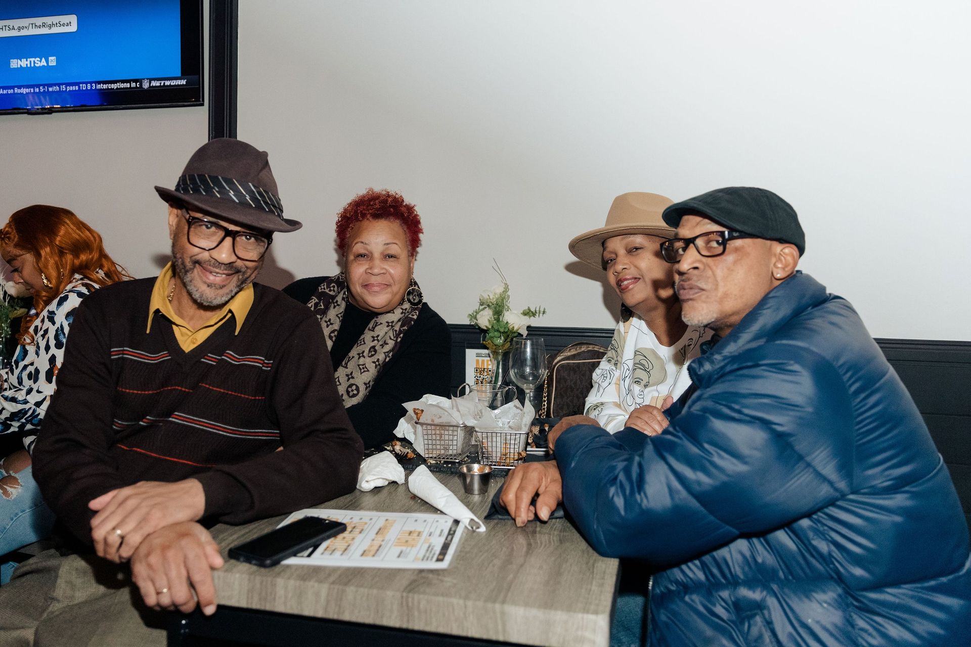 A group of people are sitting at a table in a restaurant.