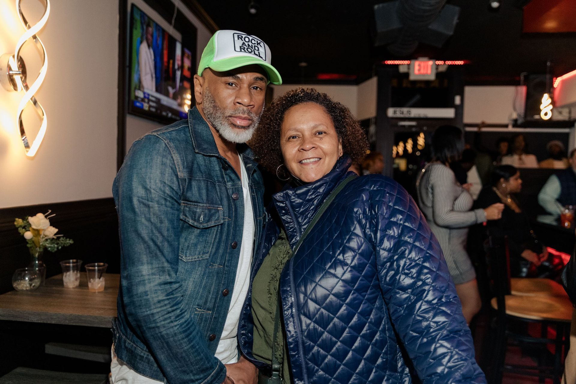 A man and a woman are posing for a picture in a restaurant.