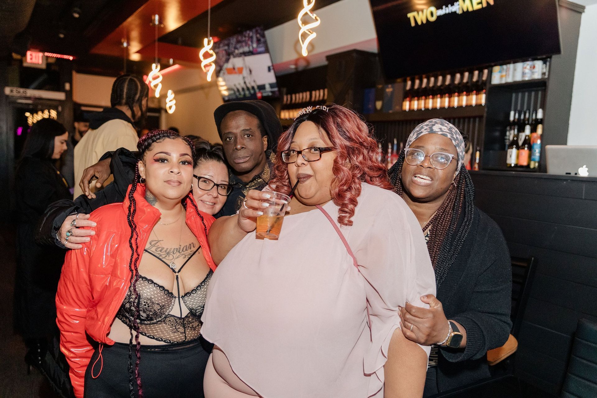 A group of people are posing for a picture in a bar.