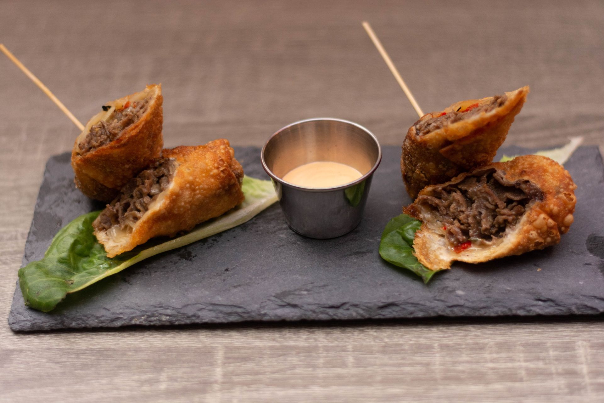 A plate of food with a dipping sauce on a table.