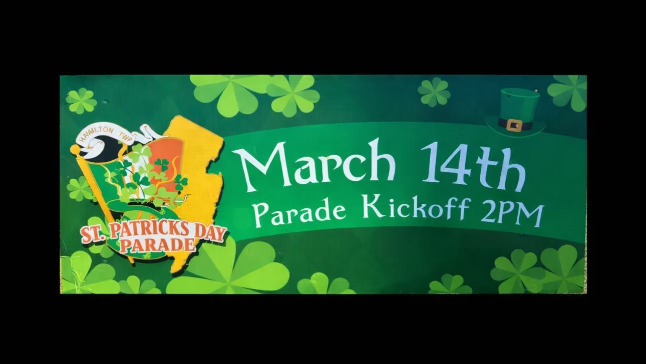 Green St. Patrick's Day parade banner: March 14th kickoff, shamrocks, hat, state outline.
