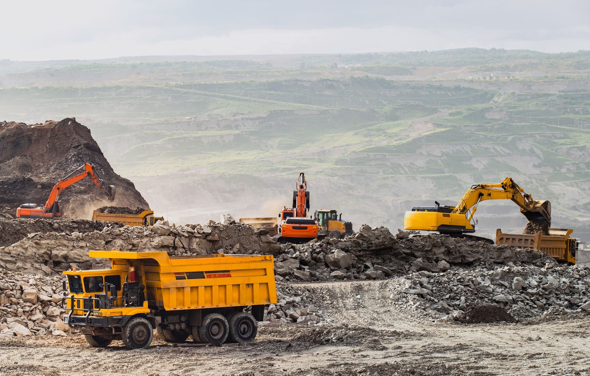 A dump truck is being loaded with rocks in a quarry.