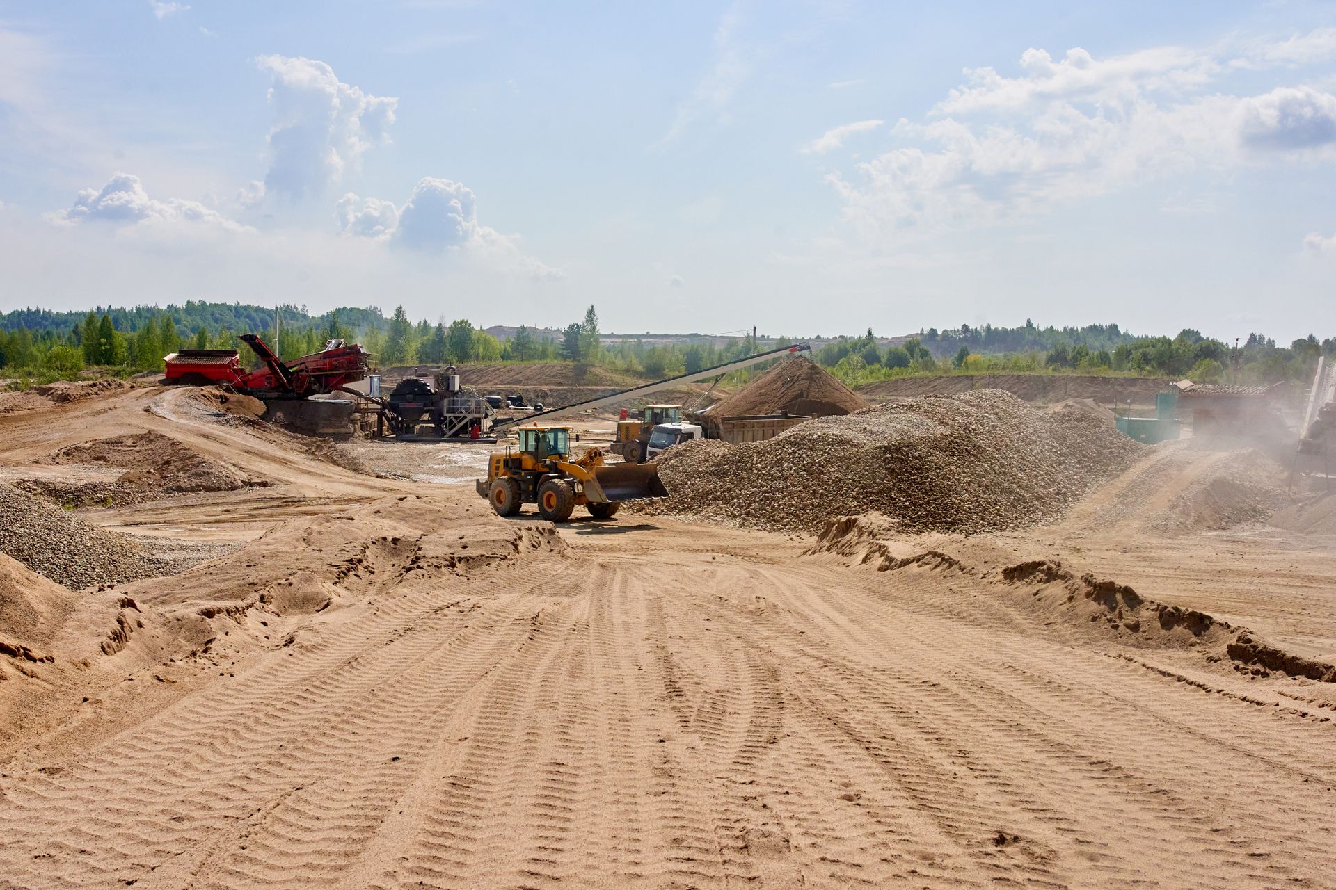 A bulldozer is driving through a dirt field.
