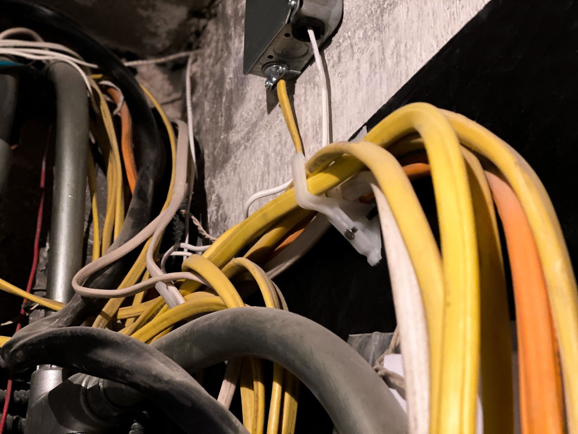 A bunch of wires are hanging on a wall